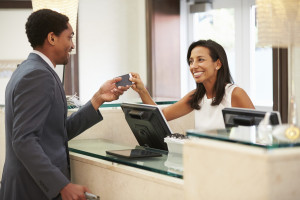 Businessman Checking In At Hotel Reception Front Desk
