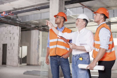 Cheerful builders are working on plan of building